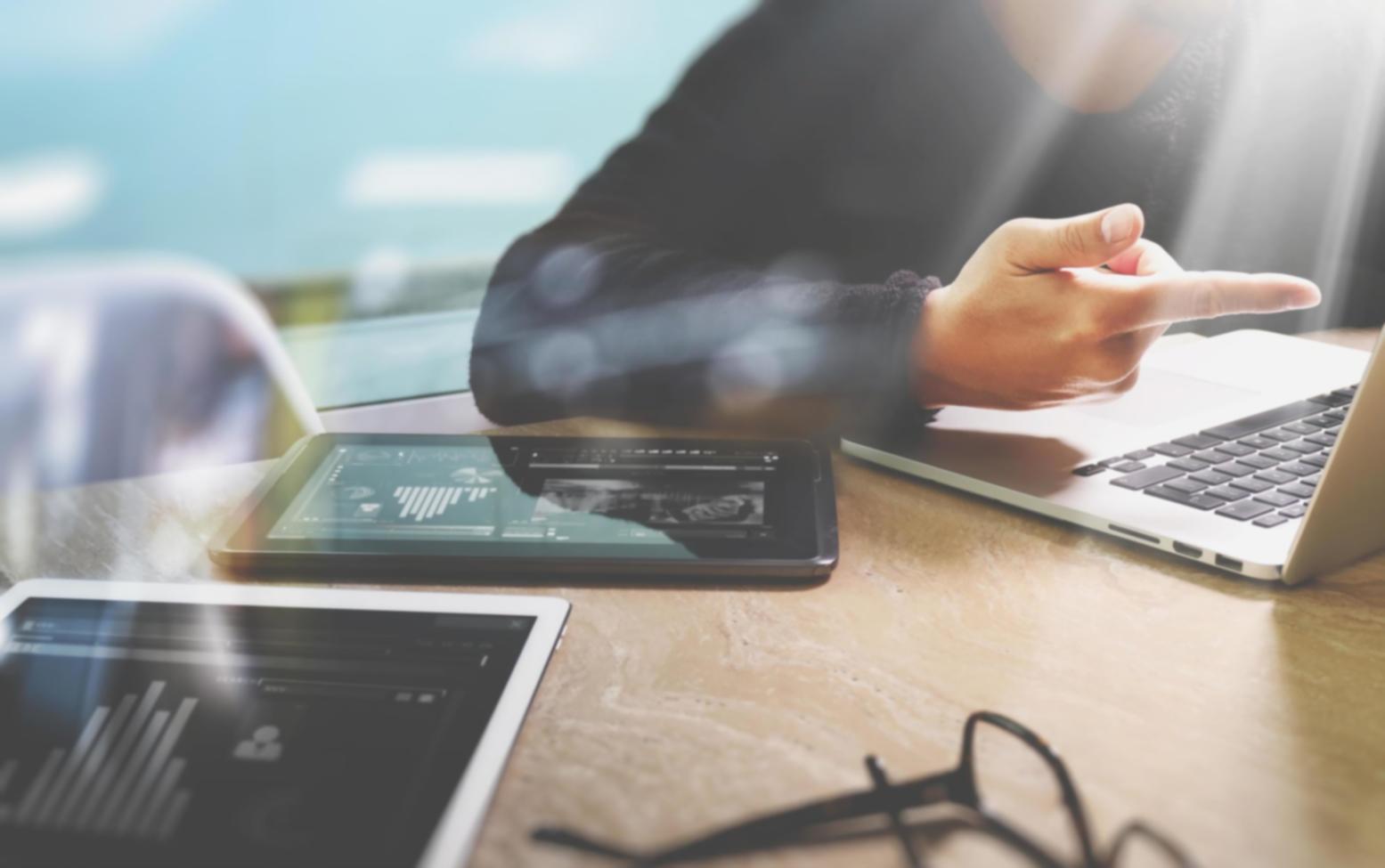 Team che collabora su progetto SEO con laptop e documenti di strategia contenuti